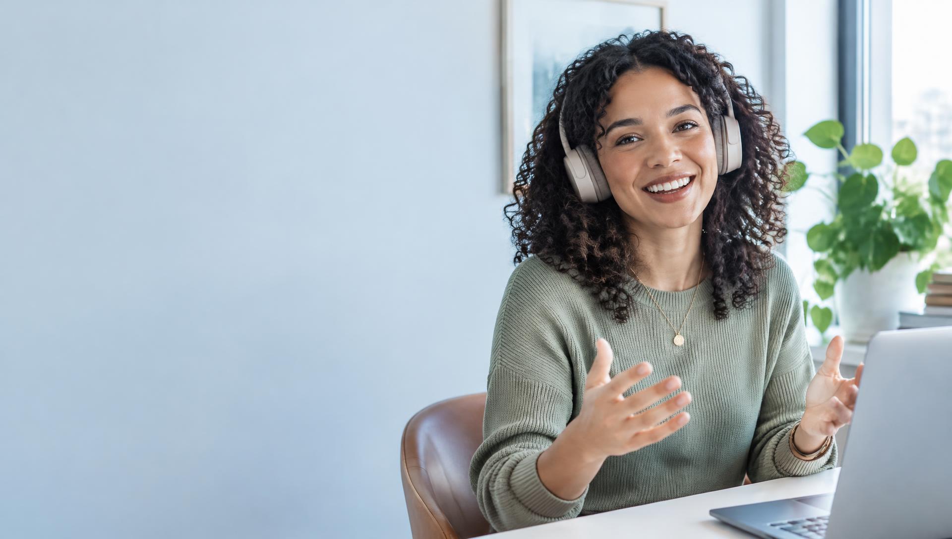 A professional having a relaxed voice conversation at her laptop